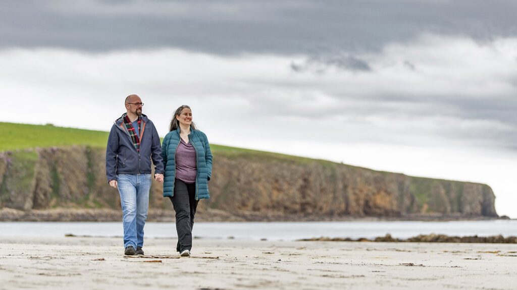 Couple strolling along Orkney's coast