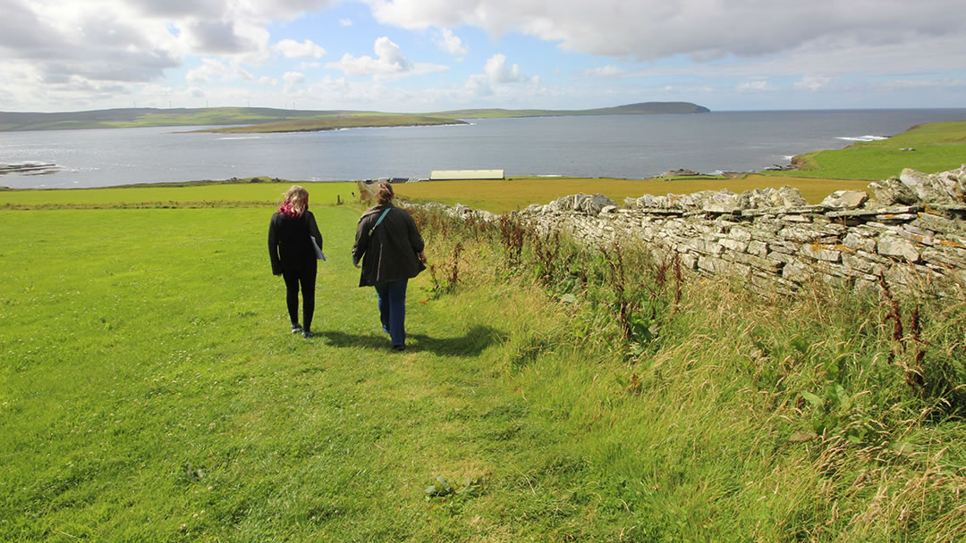 Walking downhill to Midhowe Chambered Cairn and Midhowe Broch